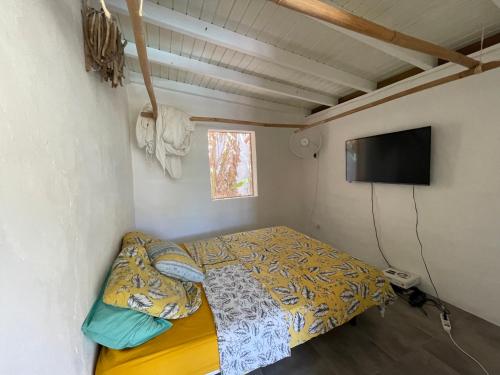 małą sypialnię z łóżkiem i telewizorem z płaskim ekranem w obiekcie Le Paradis créole w mieście Terre-de-Haut