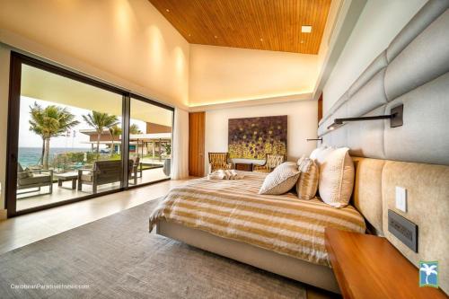 a bedroom with a bed and a view of the ocean at Sunny Vacation Villa No 31 in Bonao