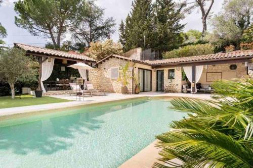 a swimming pool in front of a house at Bastide Magdaleyna Mougins in Mougins