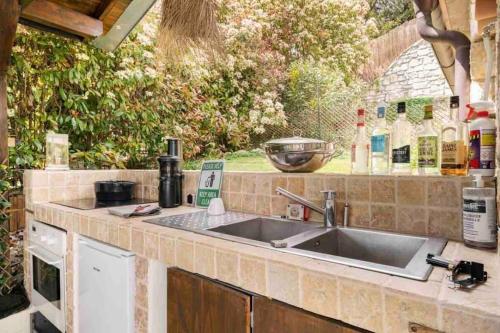 eine Küche mit einer Spüle und einer Arbeitsplatte in der Unterkunft Bastide Magdaleyna Mougins in Mougins