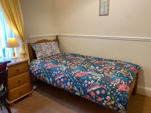 a bedroom with a bed with a colorful comforter at The Laurels in Blackpool