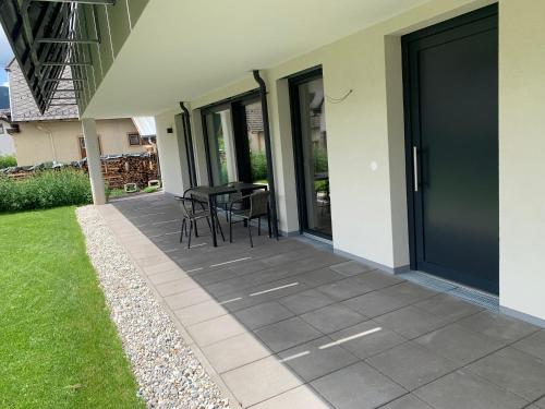 a patio with a table and chairs next to a house at Ferienwohnung Siri Zentrum mit Garten in Sankt Michael im Lungau