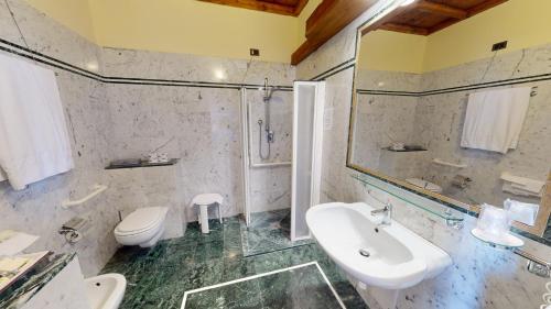 a bathroom with a sink and a shower and a toilet at Hotel Palazzo Squarcialupi in Castellina in Chianti