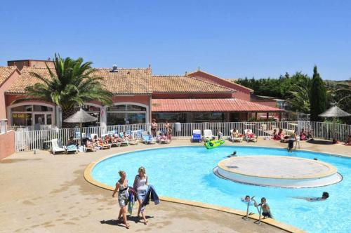 un groupe de personnes dans une piscine d'un complexe hôtelier dans l'établissement Villa 940 sur l'ile des pecheurs, au Barcarès