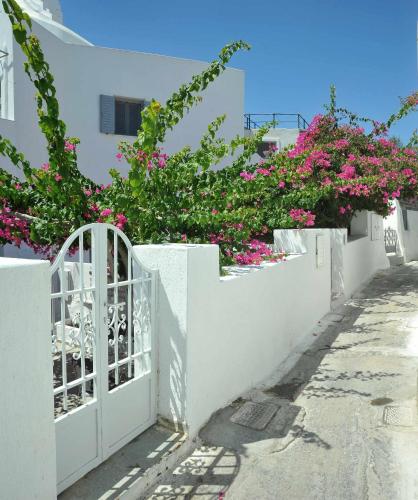 a white fence with pink flowers on a street at White Haven Cave Home in Mesaria