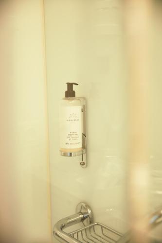 a soap dispenser on the wall of a bathroom at Alfa Inn in Blankenberge