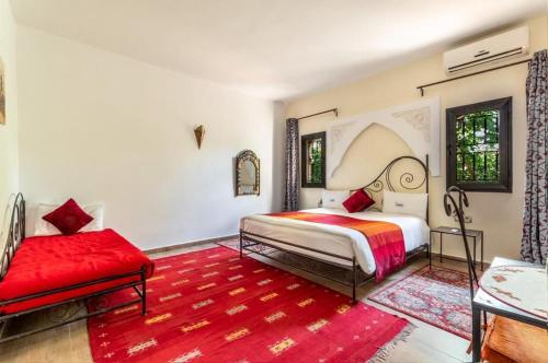 1 dormitorio con cama y alfombra roja en Riad le Ksar de Fes, en Aïn Cheggag