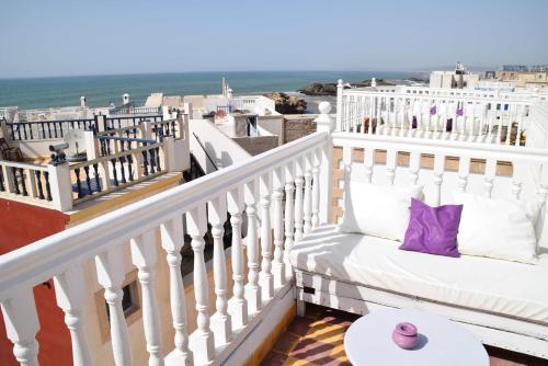 a white couch sitting on top of a balcony overlooking the ocean at Riad Saltana in Essaouira