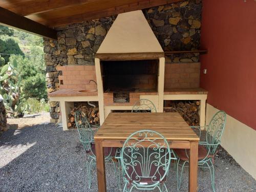 a wooden table and chairs in front of a fireplace at Casa Los Calderos in Villa de Mazo