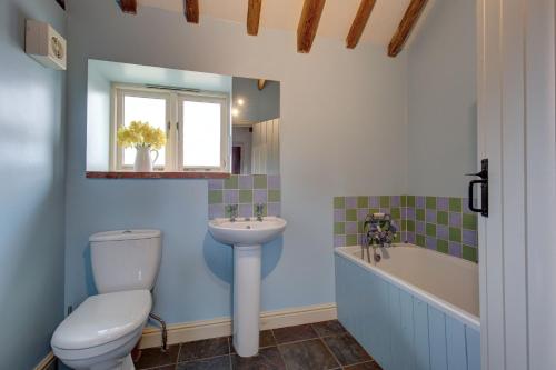 La salle de bains est pourvue de toilettes, d'un lavabo et d'une baignoire. dans l'établissement Bolt Hole, à West Beckham
