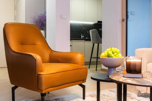 a living room with a chair and a bowl of fruit on a table at Apartman Panorama in Križevci