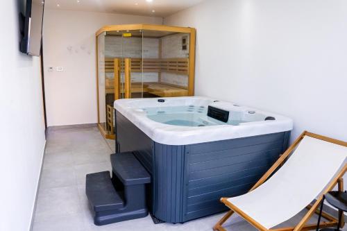 a jacuzzi tub in a room next to a chair at Apartman Panorama in Križevci