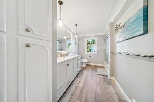 Baño blanco con lavabo y aseo en Charming Erie Home about 2 Mi to Downtown Delights!, en Erie