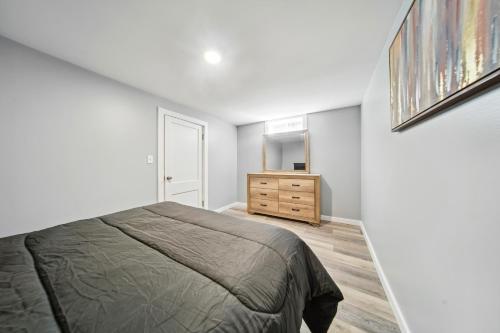 a bedroom with a bed and a dresser and a mirror at Charming Erie Home about 2 Mi to Downtown Delights! in Erie