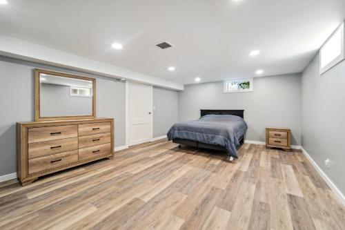 a bedroom with a bed and a dresser and a mirror at Charming Erie Home about 2 Mi to Downtown Delights! in Erie