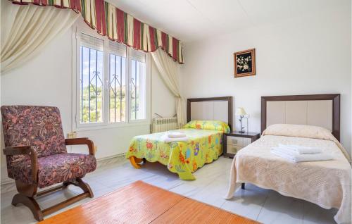 1 Schlafzimmer mit 2 Betten, einem Stuhl und einem Fenster in der Unterkunft 6 Bedroom Amazing Home In El Campillo in El Campillo