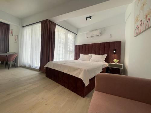 a bedroom with a large bed with a wooden headboard at L&C Platinum Property in Năvodari