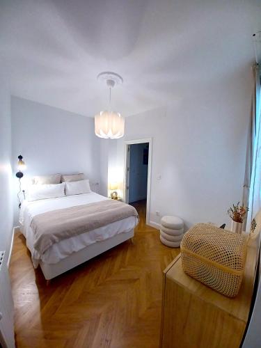 a bedroom with a large white bed and wooden floors at Apartamento Marqués de Villores centro in Albacete