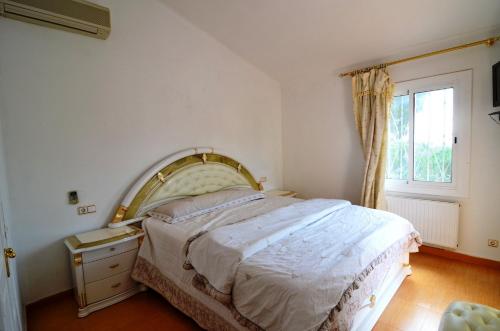 a bedroom with a large bed and a window at Villa Volendam in L'Estartit