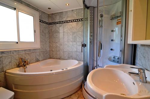 レスタルティットにあるVilla Volendamのバスルーム(シンク2台、バスタブ、シャワー付)
