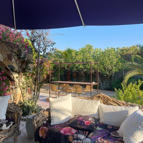 a couch sitting under an umbrella on a patio at HOTEL LA QUIETUDE in Les Issambres