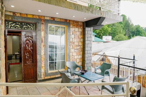 patio con mesa y sillas en el balcón en Dunleigh Apartments, en Murree