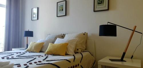 a bedroom with a bed with pillows and a lamp at A-Típica GuestHouse in Ponta Delgada