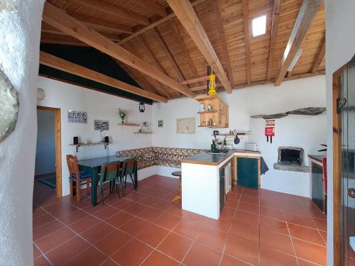 a large kitchen with a table and a stove at Casita - your home in Flores in Lajes das Flores