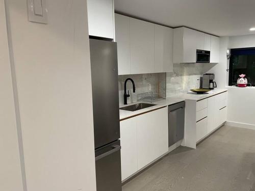 a kitchen with white cabinets and stainless steel appliances at World’s Most butful neighborhood in West Vancouver