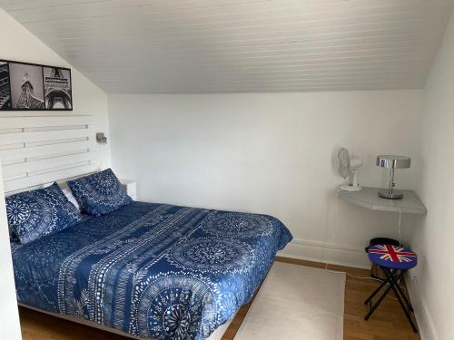 a bedroom with a bed with a blue comforter at À la maison in Saint-Étienne