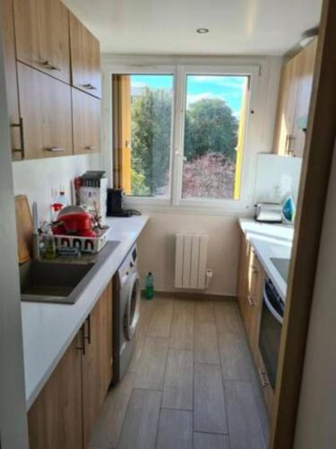 cocina pequeña con fregadero y fogones en Sunny and renovated flat in secure residence, en La Garenne-Colombes