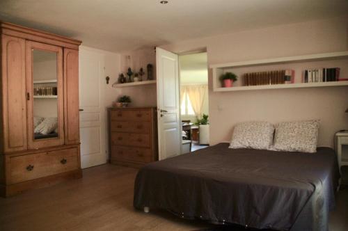 une chambre avec un lit et une commode dans l'établissement La maison d'Offaly, à Salindres