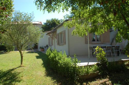 une maison avec un jardin, une table et des chaises dans l'établissement La maison d'Offaly, à Salindres