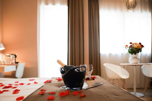 a room with a table with red flowers and a bottle of wine at Alfa Inn in Blankenberge