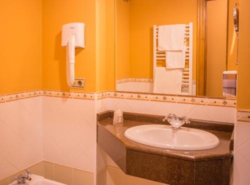 Hosteria Los Laureles في نوخا: حمام مع حوض ومرآة