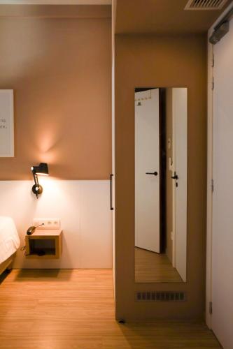 a room with a mirror and a bed and a table at Alfa Inn in Blankenberge