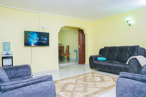 een woonkamer met 2 banken en een tv bij Entire Fully furnished Villas in Kisii in Kisii