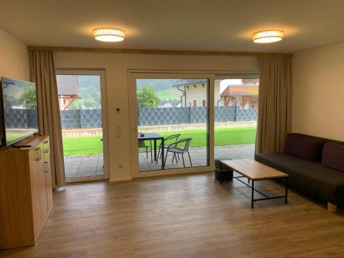 uma sala de estar com um sofá e uma mesa em Ferienwohnung Siri Zentrum mit Garten em Sankt Michael im Lungau