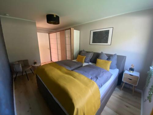 - une chambre dotée d'un grand lit avec des draps bleus et jaunes dans l'établissement Spree Chalet Cottbus, à Cottbus