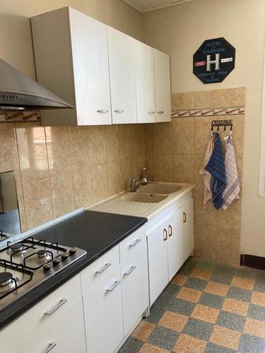 a kitchen with white cabinets and a sink and a stove at Appartement charmant centre ville in Narbonne