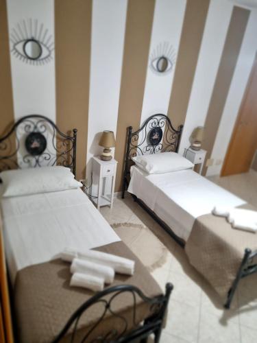 two twin beds in a room with two tables at MARY FAMILY HOME in Polverigi