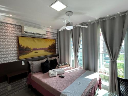 um quarto com uma cama com um quadro na parede em Flat Beira Mar de Intermares em Cabedelo