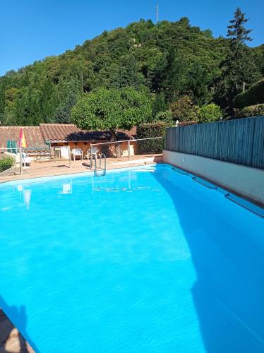 a large blue swimming pool with a hill in the background at Apartamento en pleno Montseny Mas Romeu Turisme Rural in Arbúcies