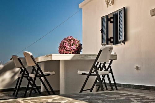three chairs sitting on a balcony with a window at Villa Stamatina in Kyra Panagia