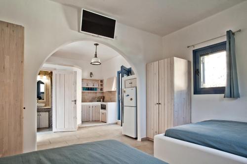 a bedroom with a bed and a kitchen with a refrigerator at Villa Stamatina in Kyra Panagia