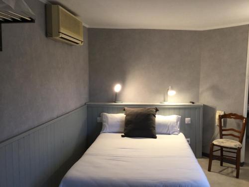 a bedroom with a bed with a black pillow on it at Pont Napoléon Moissac in Moissac
