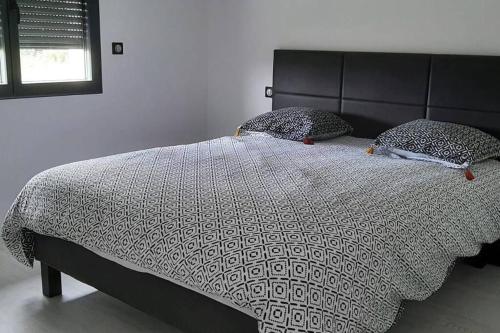 - un lit avec une couette et des oreillers en noir et blanc dans l'établissement Chez Michael, à Lunan