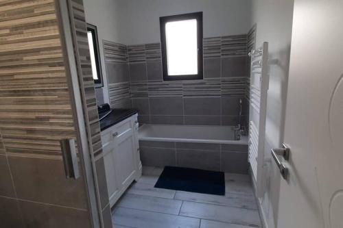 une salle de bain avec une baignoire et une fenêtre dans l'établissement Chez Michael, à Lunan