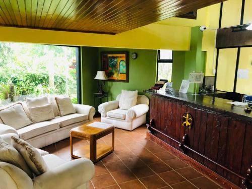 a living room with two couches and a counter at Ávita Lodge in Quesada