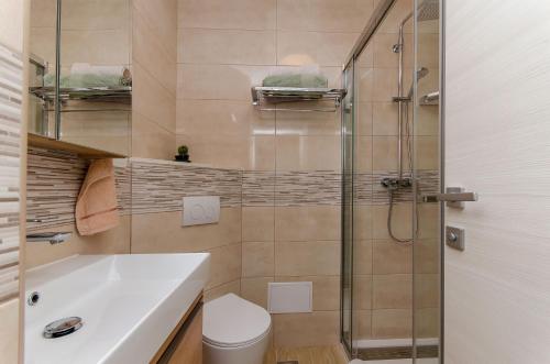 een badkamer met een douche, een toilet en een wastafel bij Modern living apartment Airy in Split